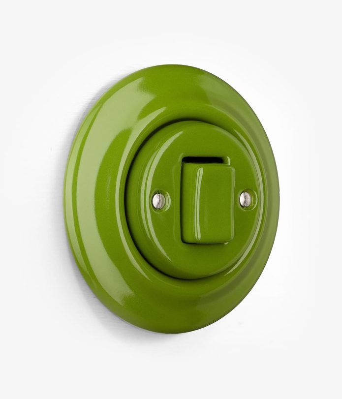 a green light switch cover on a white wall with two screws in the center