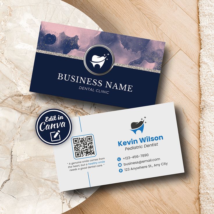 two business cards on top of a wooden table next to a white and blue badge