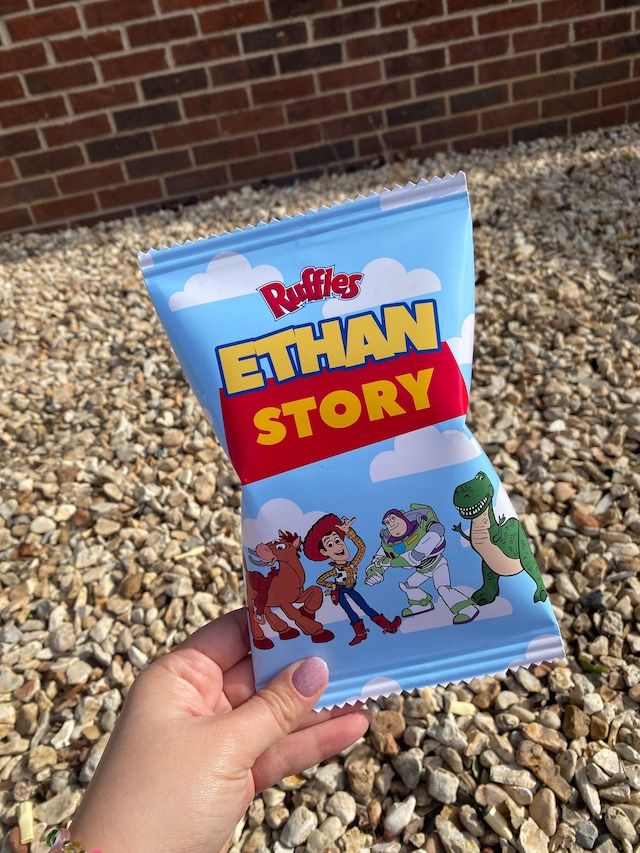 a hand holding up a bag of children's cartoon character story books in front of a brick wall