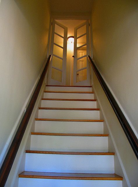 the stairs lead up to an open door