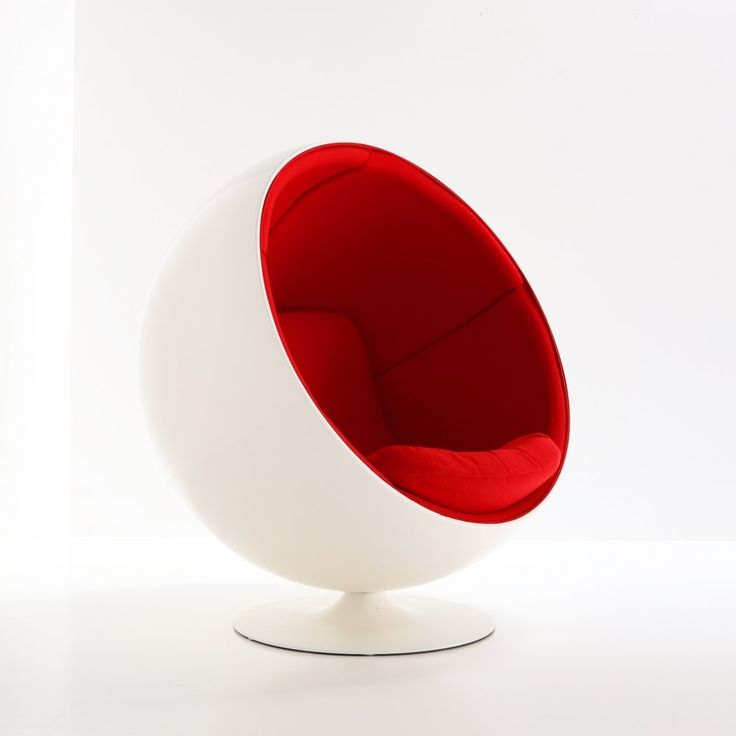 a red and white ball chair sitting on top of a white floor next to a wall