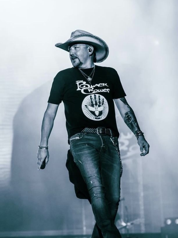 a man with a cowboy hat walking across a stage