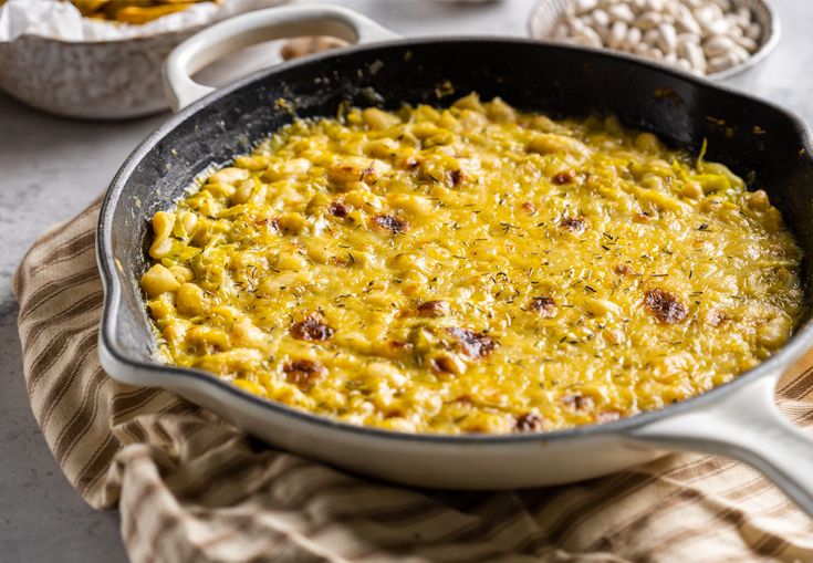 a skillet filled with macaroni and cheese on top of a table next to other dishes