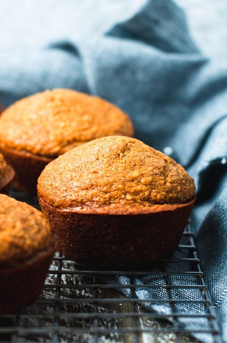 muffins cooling on a wire rack with blue cloth in the backgroud