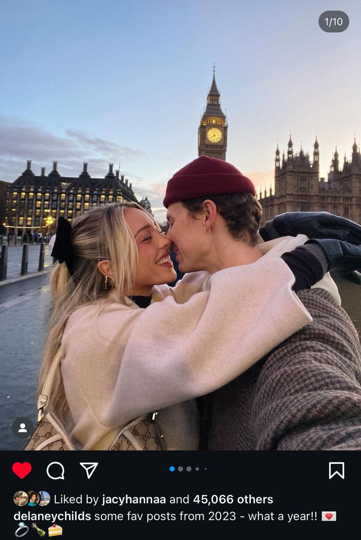 two people standing next to each other in front of big ben and the houses of parliament