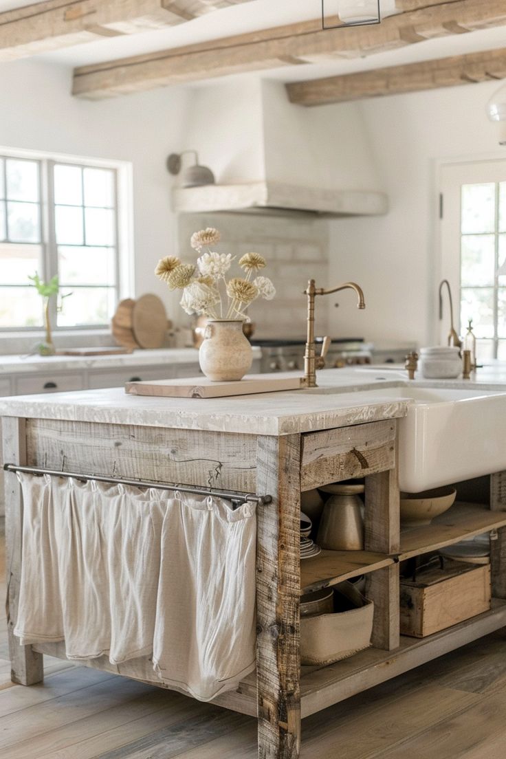 a kitchen island made out of an old wooden box with drawers underneath it and flowers in a vase on top