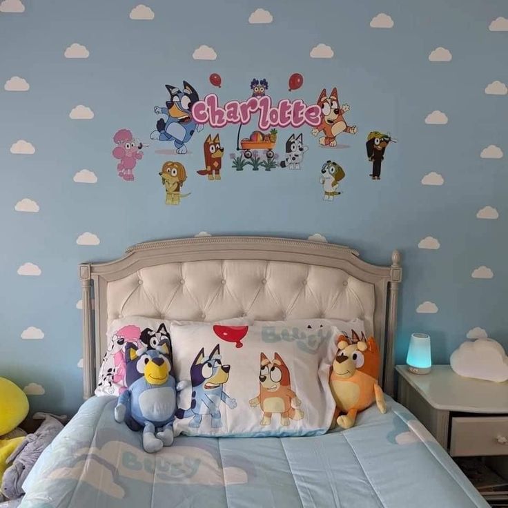 a child's bedroom with blue walls and cartoon characters on the wall