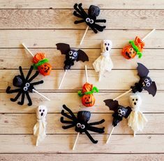 halloween cupcakes on sticks decorated with black and white icing, bats and pumpkins