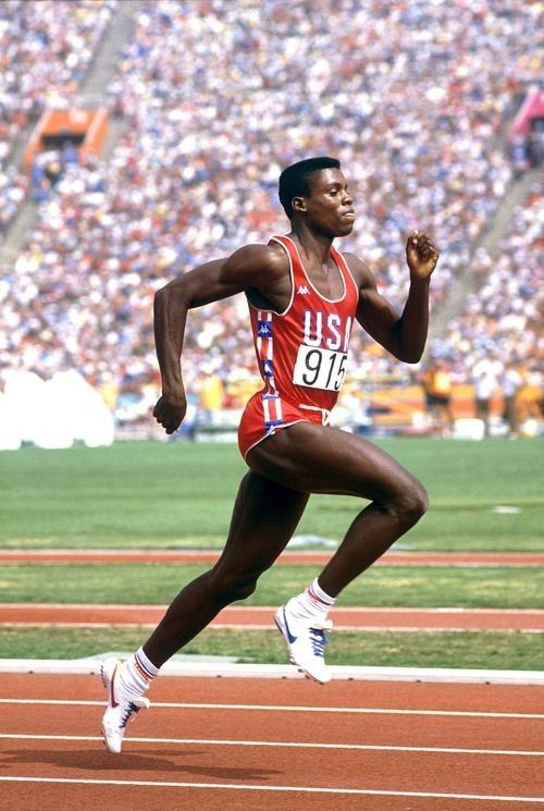 a man running on a track in front of a crowd