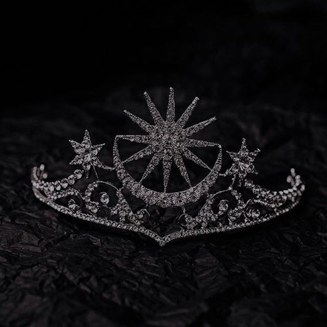 a tiara on a black surface with stars in the middle and diamonds around it