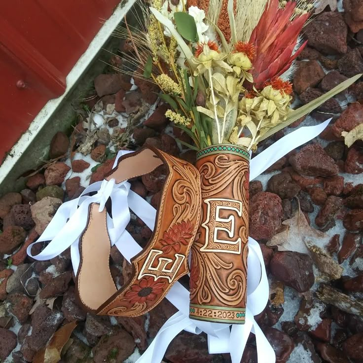 an arrangement of flowers and ribbons on the ground