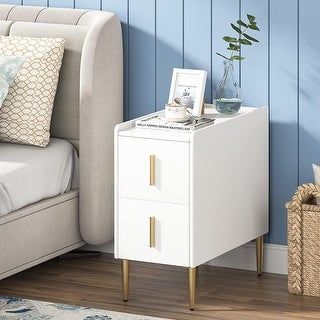 a white night stand next to a bed with blue walls and wooden flooring in a bedroom