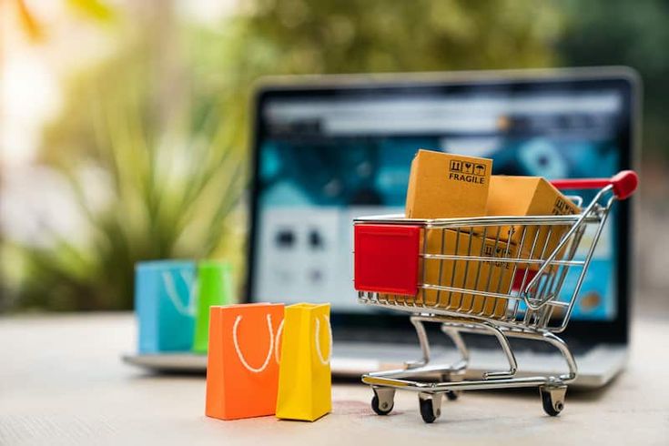 a shopping cart sitting in front of a laptop