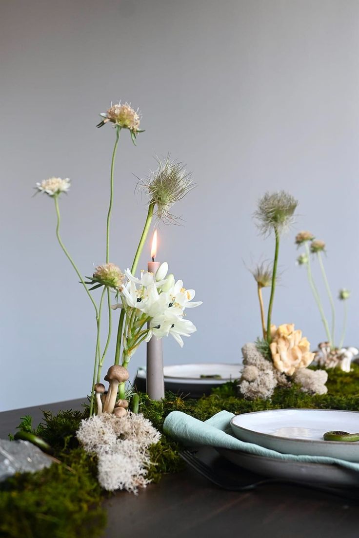 the table is decorated with moss and flowers