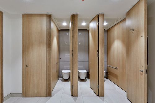 an empty bathroom with wooden doors and urinals