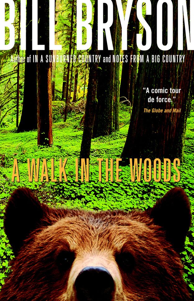 a walk in the woods movie poster with a bear's face and trees behind it