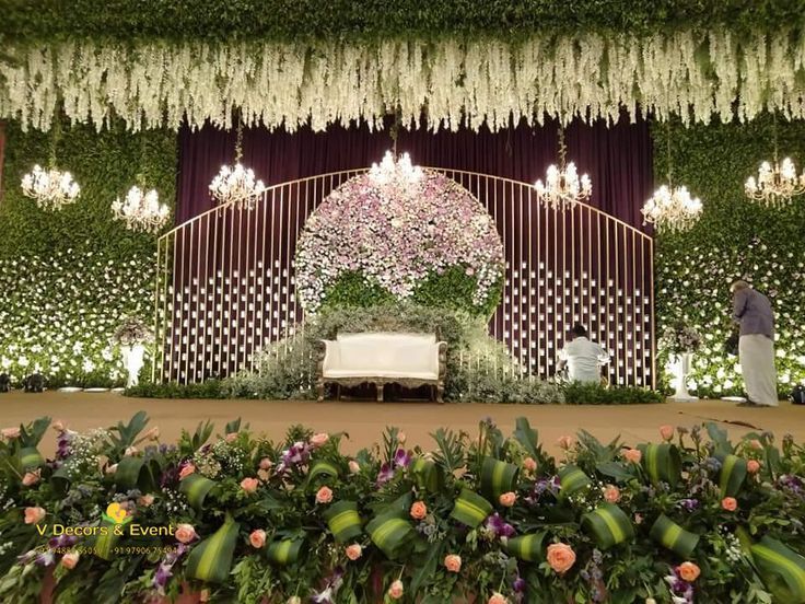 the stage is decorated with flowers and greenery