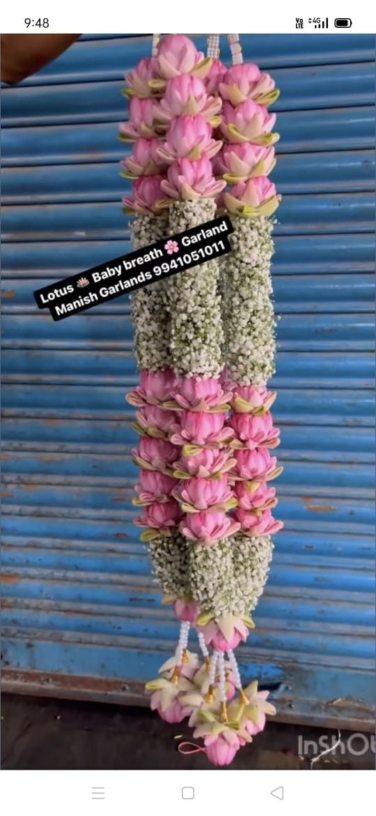 pink and white flowers hanging from the side of a blue door with words on it