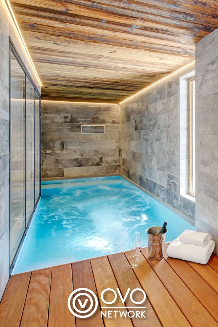 an indoor swimming pool with wooden flooring and walls that have been made out of wood