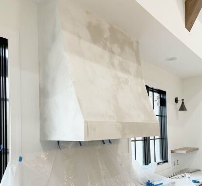 a kitchen being remodeled with white walls and counters covered in plastic wrap around the stove hood