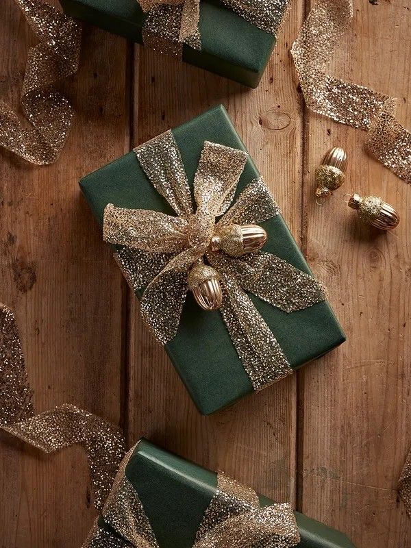 two presents wrapped in green and gold ribbon