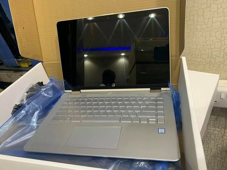 an open laptop computer sitting on top of a white box next to a blue light