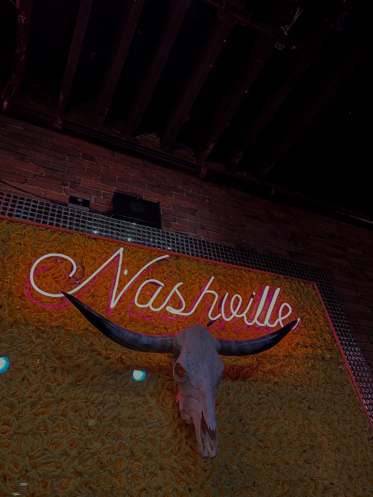 a long horn steer skull on display in front of a nashville sign that says nashville