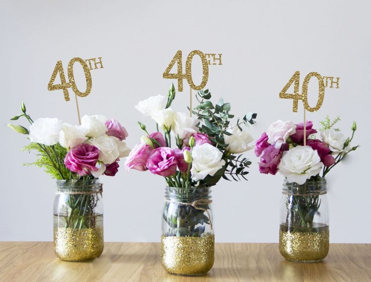 three mason jars with flowers in them on a table