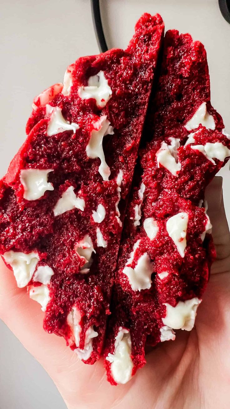 red velvet cookies with white frosting in someone's hand