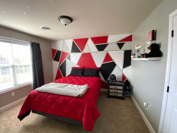 a bed room with a neatly made bed and a red blanket on the top of it