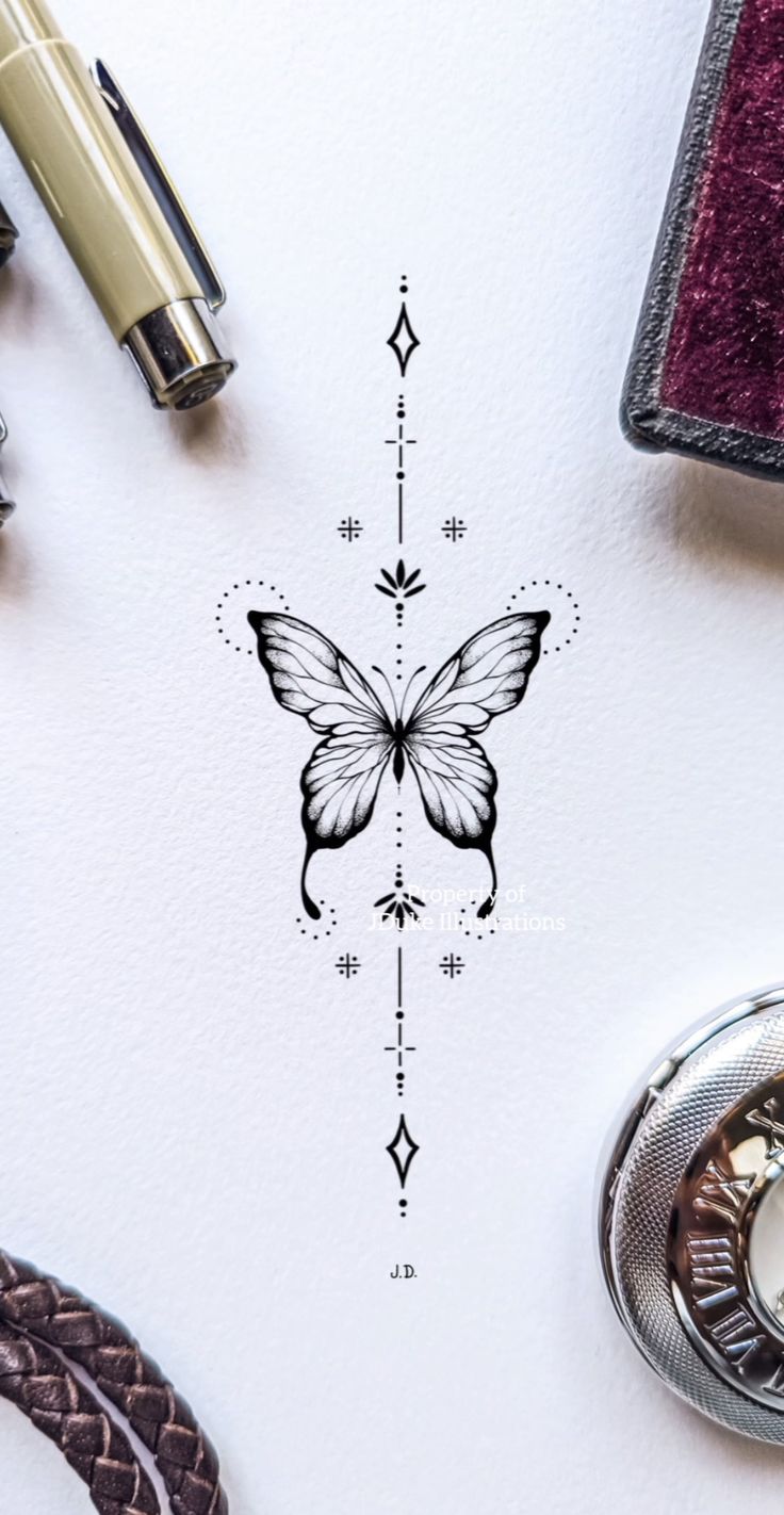 a drawing of a butterfly on top of a white paper next to some pens and other items