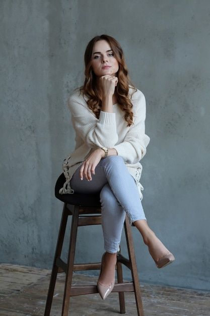 a woman sitting on top of a wooden stool