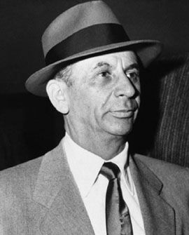 a man in a suit and tie wearing a hat