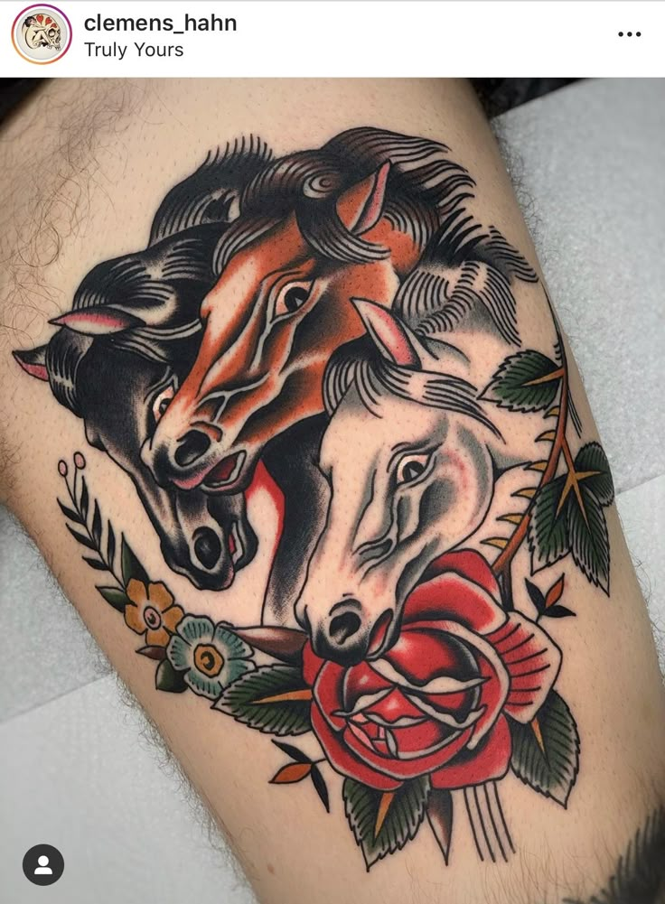 a tattoo with two horses and roses on the side of a man's leg