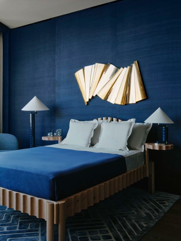 a bedroom with blue walls and gold accents