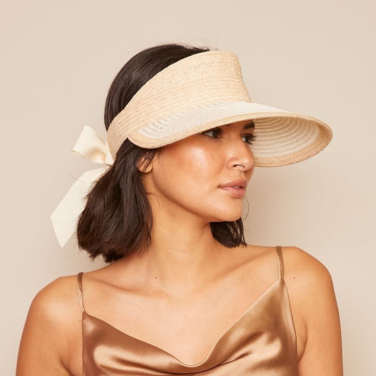 Our Ricky' visor looks so chic as it protects your face from the sun. It's woven from a Natural and Ivory two-tone straw and finished with an elasticated panel lined with smooth satin at the back topped with flowing ivory grosgrain ties.Measurements: HEADSIZE: 6.5" / 2.75" X 4.50"Spot cleanImported Elegant Adjustable Straw Hat With Upf 50+, Chic Visor Straw Hat With Uv Protection, Chic Straw Visor Hat With Uv Protection, Elegant Adjustable Straw Hat With Uv Protection, Chic Cream Straw Hat, Elegant Boater Hat With Visor For Vacation, Elegant Visor Boater Hat For Vacation, Chic Straw Visor Hat, Chic Cream Toquilla Straw Sun Hat