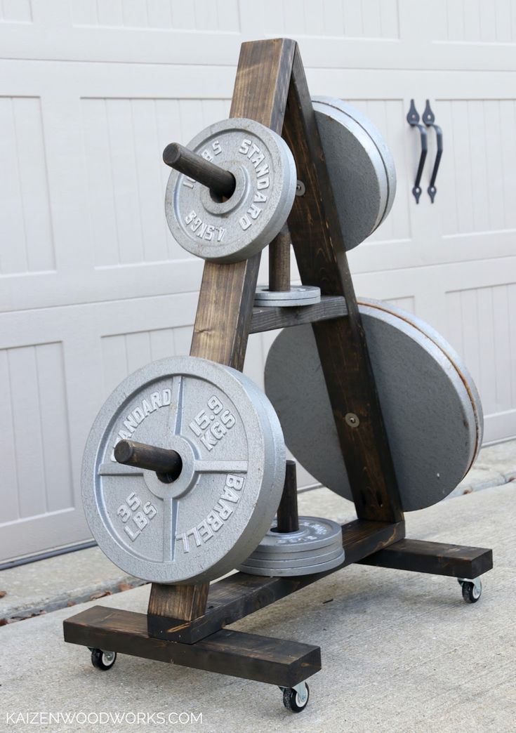 a pair of dumbbells sitting on top of a wooden stand in front of a garage door