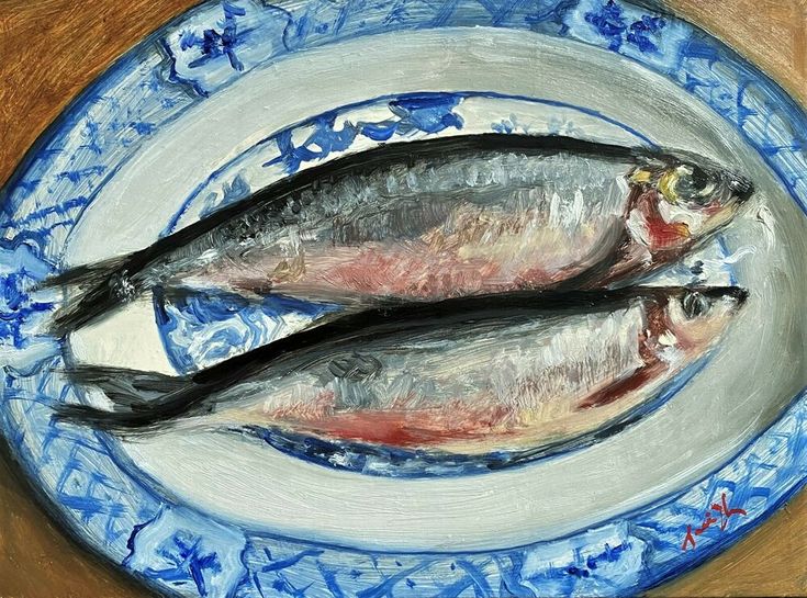 two fish sitting on top of a blue and white plate