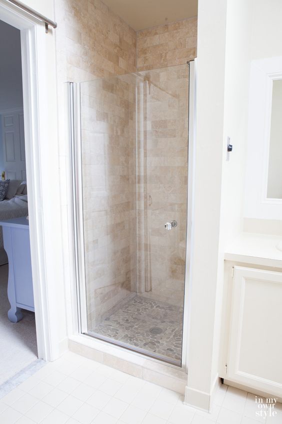 a walk in shower sitting inside of a bathroom