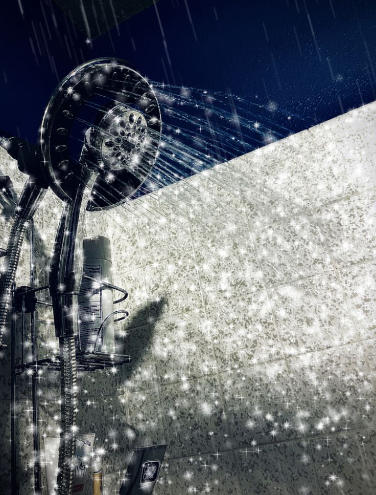 an artistic image of a shower head and hand held faucet in the rain