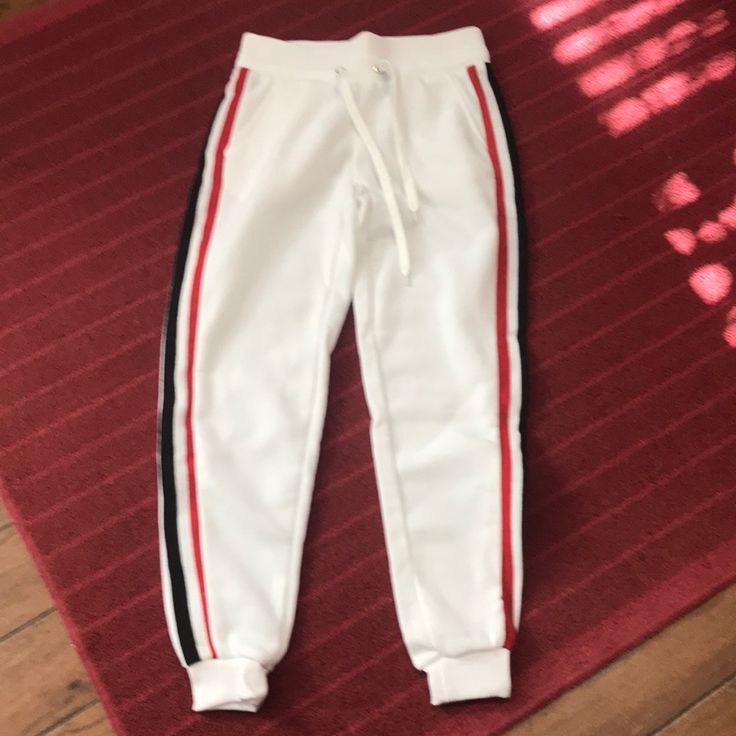 Nwt. White/ Black & Red Striped . Medium Ribbed Waist &. Ankle Trendy White Sweatpants For Winter, Trendy White Winter Sweatpants, Trendy White Jogging Bottoms, Winter White Stretch Pants, White Fitted Sweatpants For Loungewear, White Fitted Sweatpants, White Sportswear Joggers With Side Stripes, White Stretch Jogging Pants, Stretch White Jogging Pants