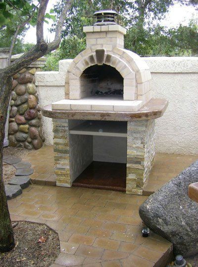 an outdoor pizza oven in the middle of a patio