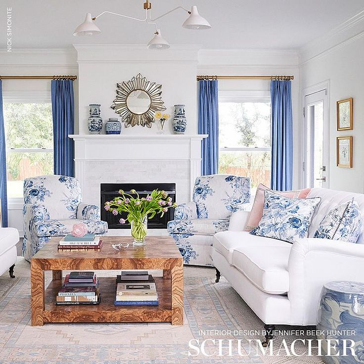 a living room filled with furniture and a fire place in front of a white fireplace