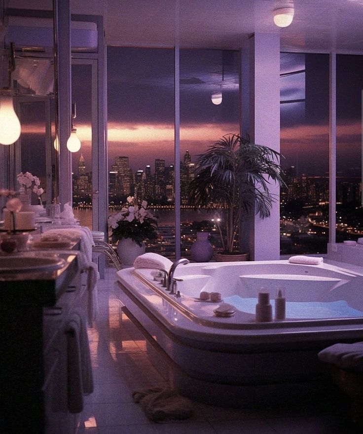 a bathroom with a large jacuzzi tub next to a window overlooking the city