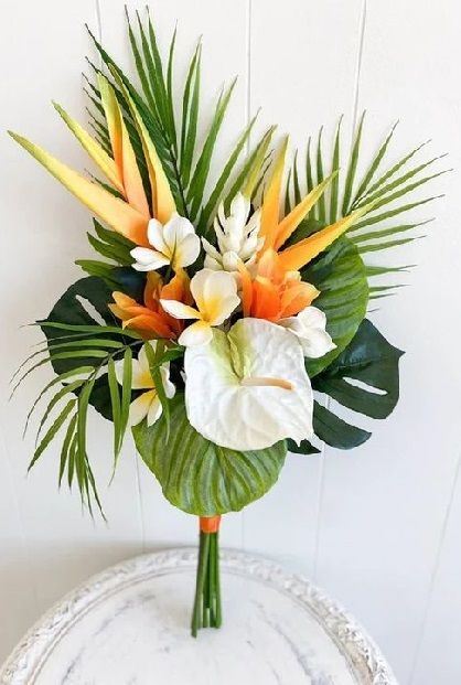 an arrangement of tropical flowers in a vase