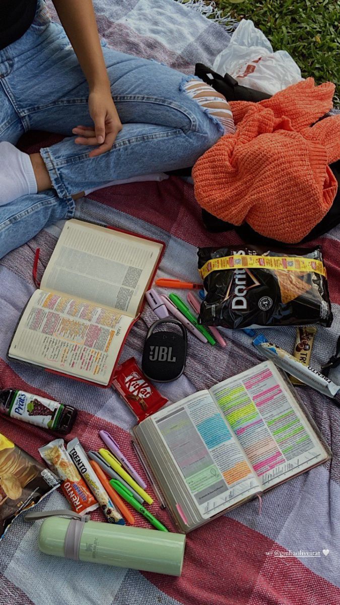 a person sitting on a blanket with books and other items