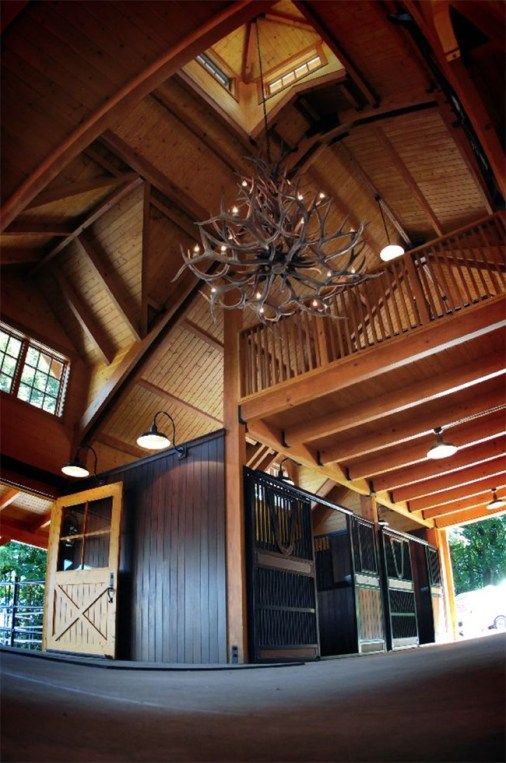 the inside of a horse barn with chandelier