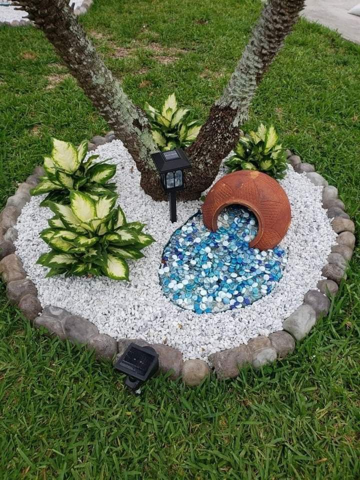 there is a small garden with rocks and plants in the center, along with two palm trees