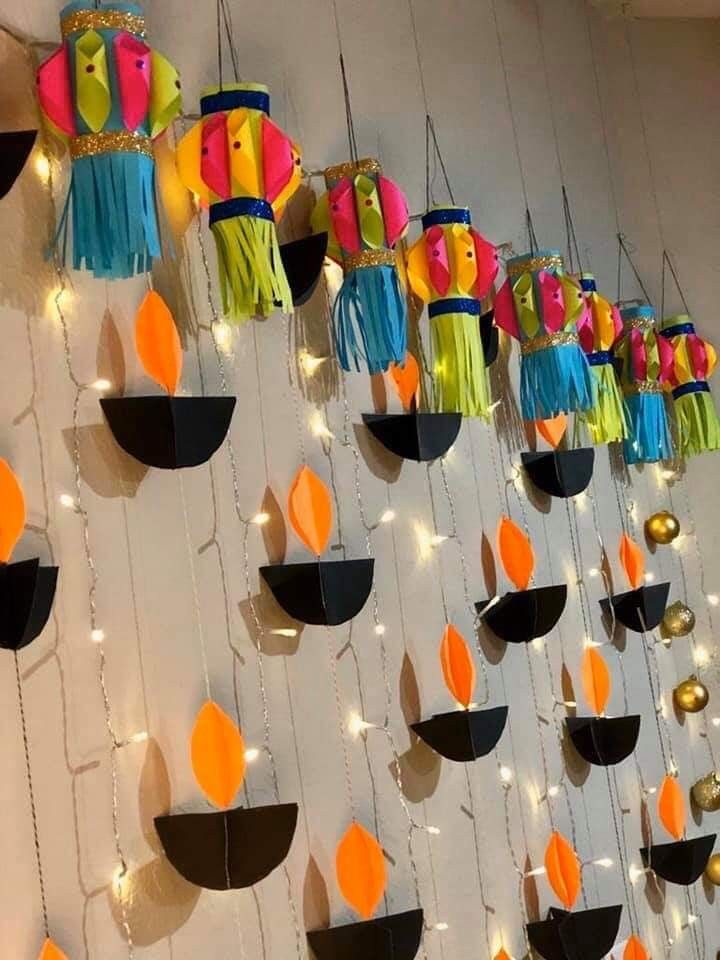 colorful paper lanterns are hanging on the wall with string lights strung from them to create an artistic display