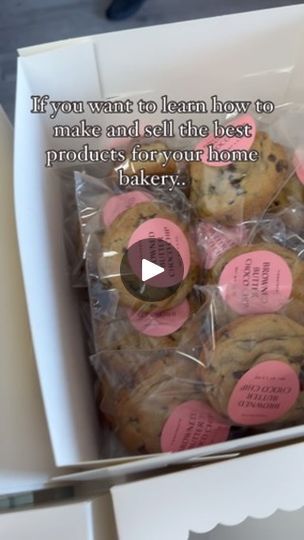 a box filled with lots of cookies covered in frosting and pink sticker labels